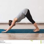 pregnant woman doing prenatal yoga downward facing dog posture studio turquoise mat 115438030